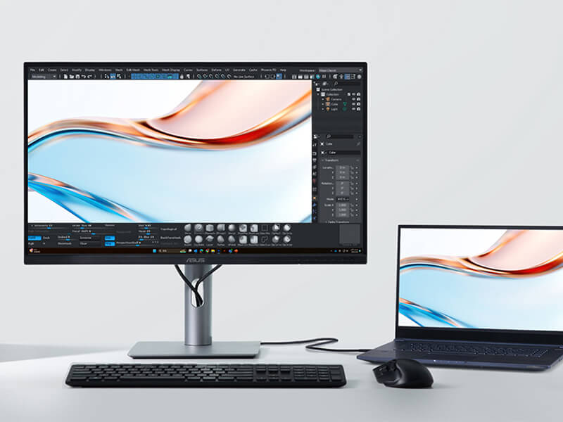 A sleek desktop setup showing a ProArt monitor displaying vibrant digital art beside a laptop.